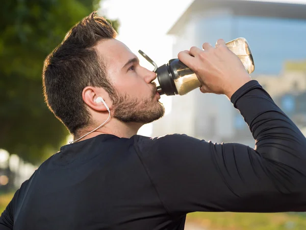 Bell'uomo che beve acqua in una giornata di sole — Foto Stock