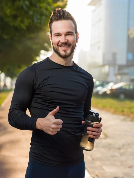 ハンサムな男は、晴れた日に水を飲む — ストック写真