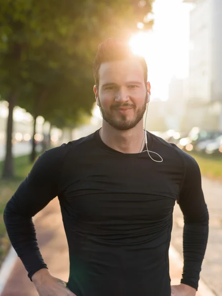 Muscular build handsome athlete resting after a morning run stan — Stock Photo, Image