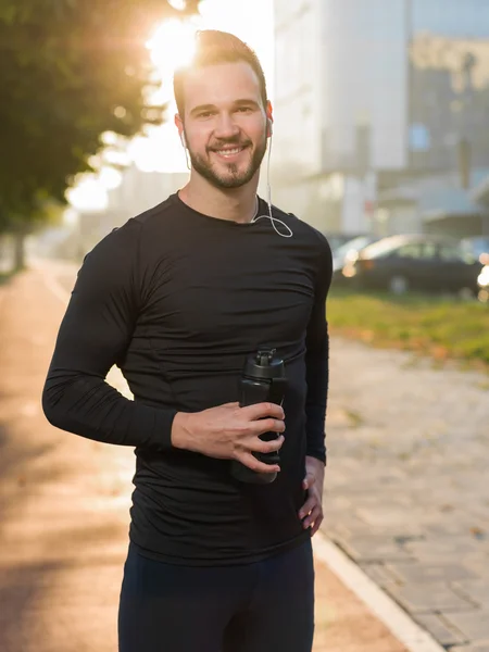 Muscular construir apuesto atleta descansando después de una mañana ejecutar stan — Foto de Stock