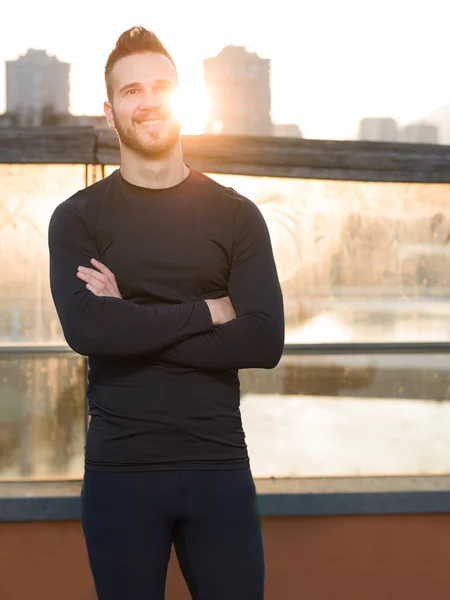 Atlético guapo hombre en negro entrenamiento ropa corriendo en el r — Foto de Stock