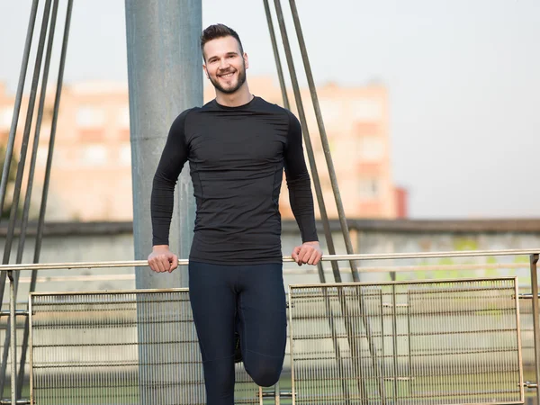 Joggen gezond ogende Young Man Kruis brug onder ochtend zon — Stockfoto