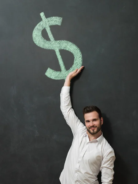 Man standing in front of dollar sign — Stock Photo, Image