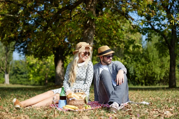 Casal jovem deitado no chão no parque e desfrutando de sua — Fotografia de Stock