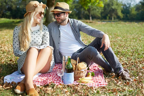 Jong (echt) paar liggend op de grond in het park en genieten van hun — Stockfoto