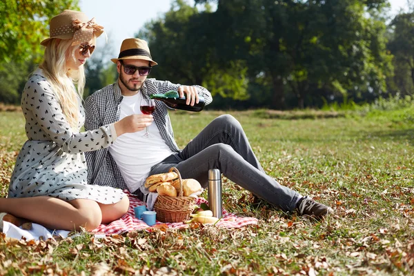 Jong (echt) paar liggend op de grond in het park en genieten van hun — Stockfoto