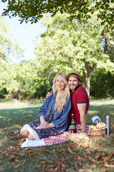 Happy young couple relaxing on the lawn in a summer park. Love c — Stock Photo, Image