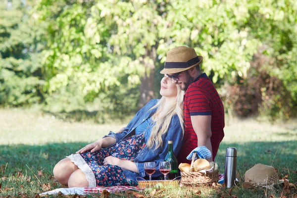 Feliz casal jovem relaxando no gramado em um parque de verão. Amor c — Fotografia de Stock