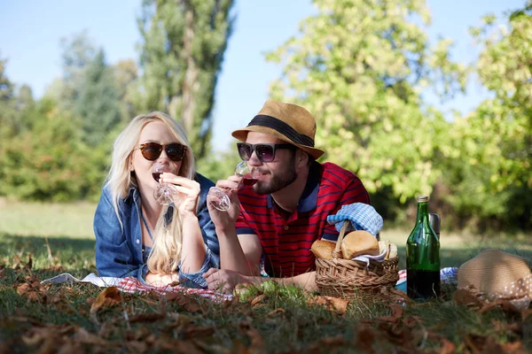 Gelukkige jonge paar ontspannen op het gazon in een park van de zomer. Liefde c — Stockfoto