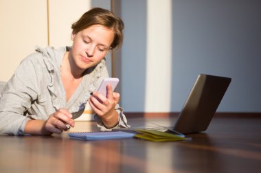 Dizüstü bilgisayar ve telefon kullanan çekici beyaz kız