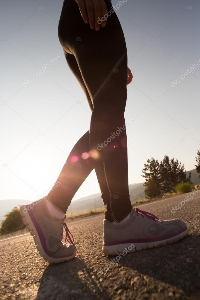 Young woman stretching before running in the early evening, inst