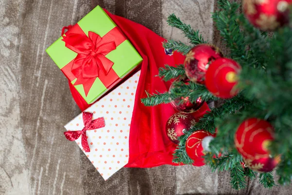 Arbre de Noël avec boîte cadeau et décorations sur fond en bois — Photo