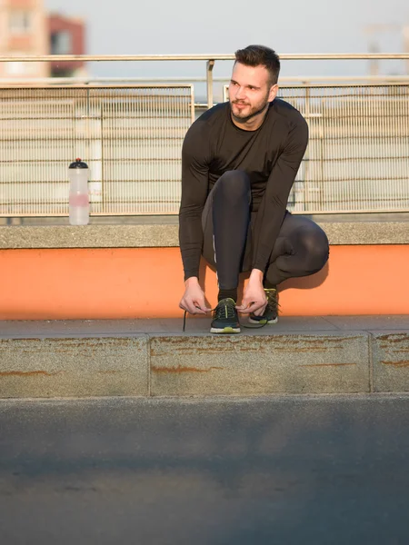 Estilo de vida saludable hombre deportivo atando cordones antes de correr, oro — Foto de Stock