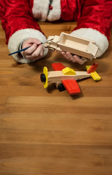 Santa Claus Dokonywanie zabawki. Malarstwo i kolorowanie zabawki drewniane — Zdjęcie stockowe
