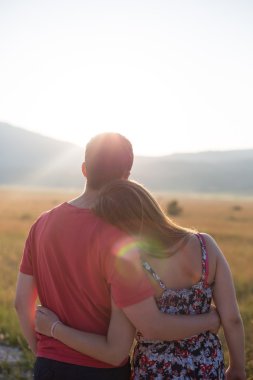 Genç çiftin zevk çayır günbatımında