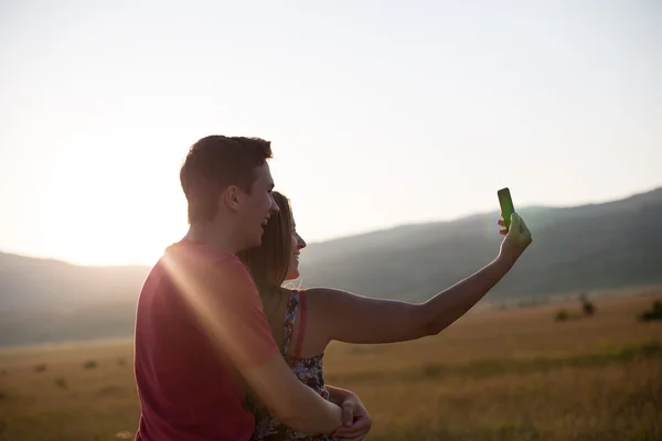 Jonge mooie paar op de achtergrond van de zonsondergang — Stockfoto