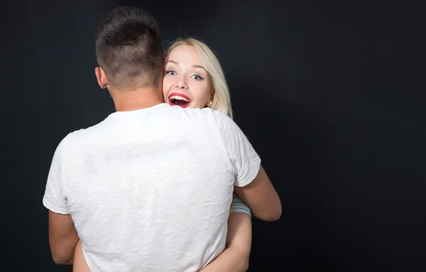 Casal de família bonito abraçando em casa. Mulher olhando para a câmera . — Fotografia de Stock