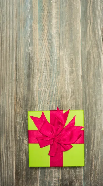 Regalo de Navidad envuelto en papel sobre un fondo de madera para una — Foto de Stock