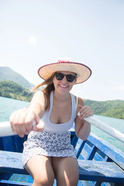 Молодая женщина гребёт на лодке в летний день — стоковое фото