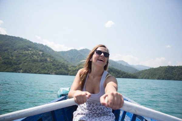 Uma jovem está remando um barco em um dia de verão — Fotografia de Stock