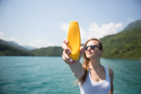 Solskyddsmedel kvinna tillämpa sololja visar flaska. Vacker — Stockfoto