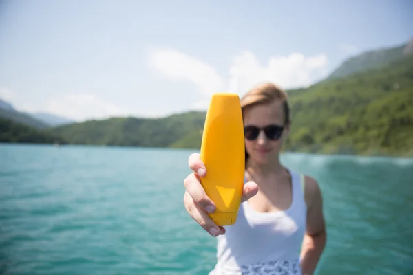 Solskyddsmedel kvinna tillämpa sololja visar flaska. Vacker — Stockfoto