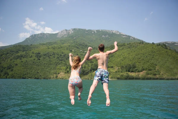 Jong koppel springen op de rand van een boot — Stockfoto