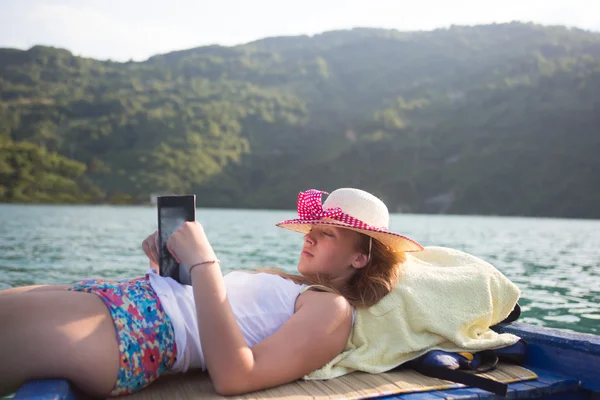 Hipster girl reading a book on the boat — Stock Photo, Image