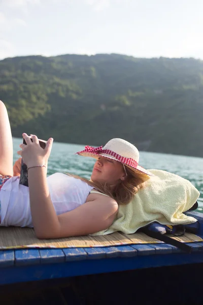 Hipster meisje het lezen van een boek op de boot — Stockfoto