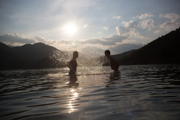 Silhoueted giovane coppia in spiaggia in una nebbiosa giornata estiva a dus — Foto Stock