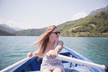 Genç bir kadın bir yaz gününde bir tekne kürek