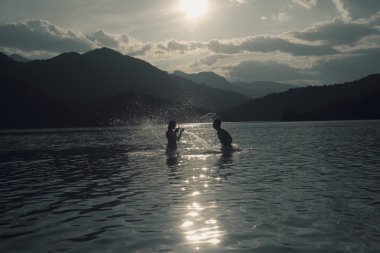 Dus, Puslu yaz gününde plajda Silhoueted genç Çift