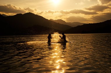 Dus, Puslu yaz gününde plajda Silhoueted genç Çift