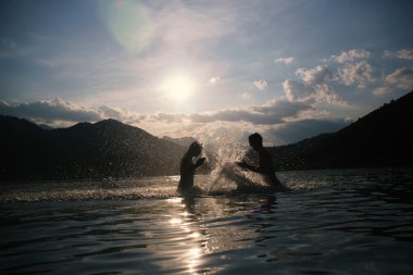 Dus, Puslu yaz gününde plajda Silhoueted genç Çift