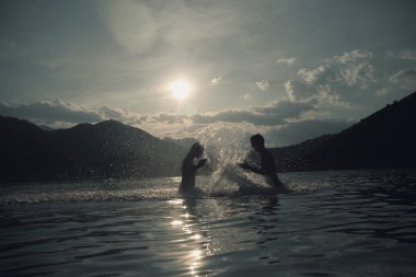 Dus, Puslu yaz gününde plajda Silhoueted genç Çift