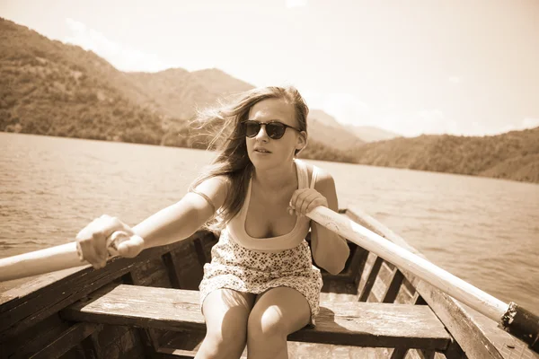 Une jeune femme ramant un bateau un jour d'été — Photo