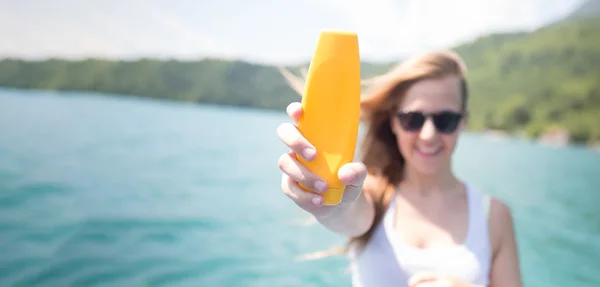 Zonnebrandcrème vrouw zonnecrème fles tonen toe te passen. Mooie — Stockfoto