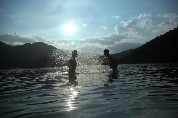 Silhoueted a fiatal pár a strandon egy párás nyári napon a dus — Stock Fotó