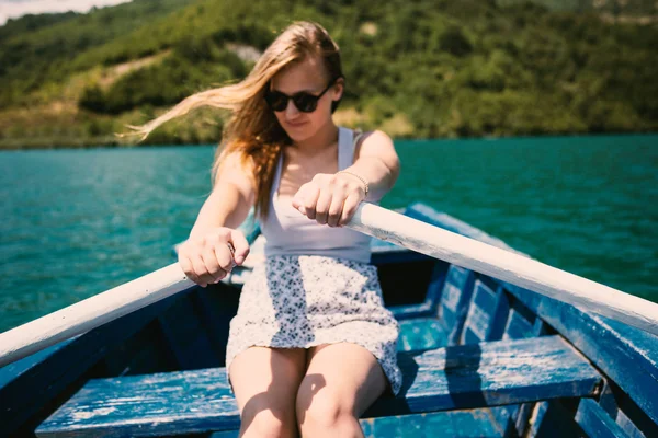 Eine junge Frau rudert an einem Sommertag ein Boot — Stockfoto