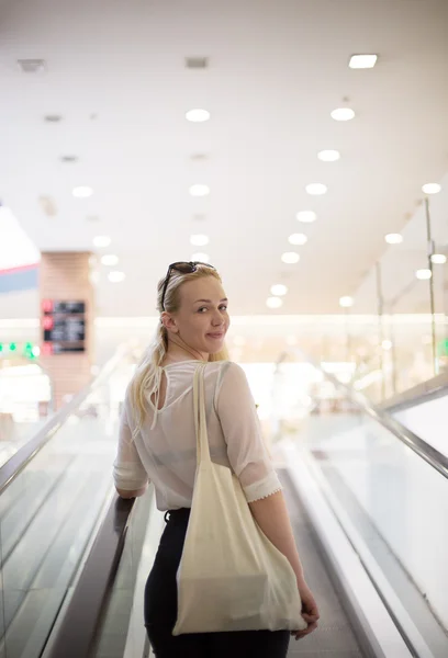 Alegre bonita jovem senhora tomando o passeio de escada rolante e shoppin — Fotografia de Stock