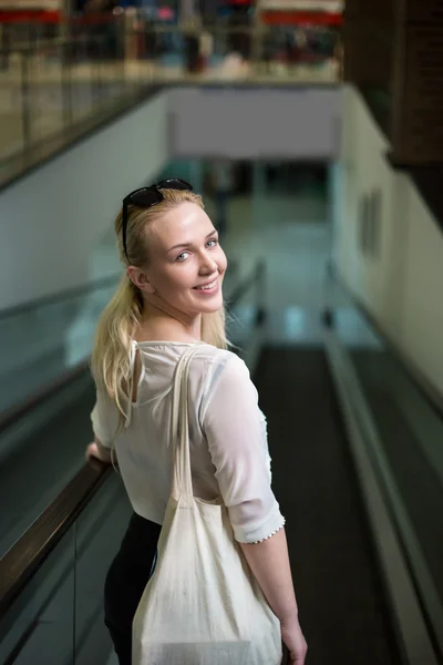 Joyeux Jolie jeune femme prenant l'escalator Ride et shoppin — Photo