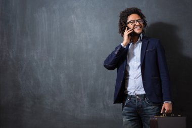 fon kullanarak kara tahta bavula ile genç afro adam resmi