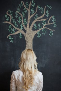 Çizim tebeşir para ağacı önünde mutlu sarışın iş kadını