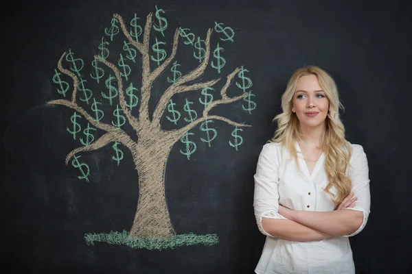 Happy blonde Business woman in front of chalk money tree drawing — Stock Photo, Image