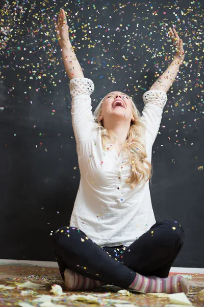 Laughing girl  under a rain of confetti. Filter effect added. — Stock Photo, Image