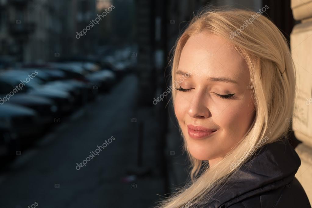 Attractive Young Blonde Haired Girl Posing For The Camera Agains