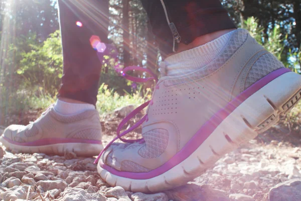 Closeup of female legs jogging on a trail, instagram tone, flare — Stock Photo, Image