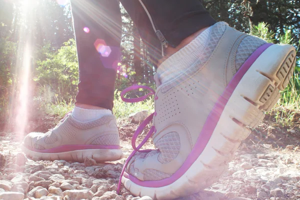 Closeup of female legs jogging on a trail, instagram tone, flare — Stock Photo, Image