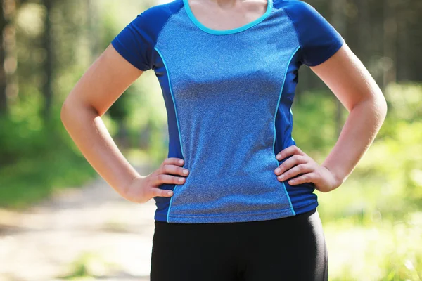 Recortado tiro de la mujer en forma en ropa deportiva de pie con su mano —  Fotos de Stock