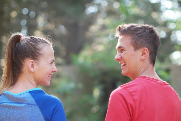 Una feliz pareja mirando el uno al otro y caminando en el bosque ho — Foto de Stock